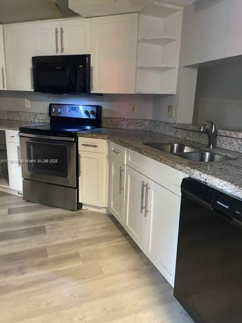 kitchen featuring a sink, open shelves, black appliances, and white cabinets