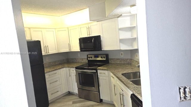 kitchen featuring black appliances, open shelves, light wood-style floors, a textured ceiling, and a sink