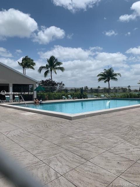pool with a patio area and fence