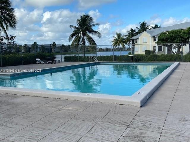 community pool with a patio and fence
