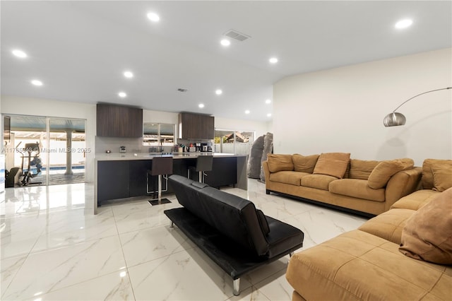 living room with visible vents, recessed lighting, and marble finish floor