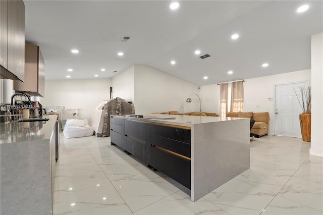 kitchen featuring open floor plan, a large island, a sink, and marble finish floor