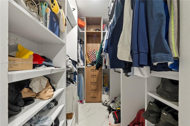 walk in closet featuring marble finish floor