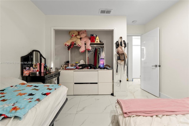 bedroom with a closet, marble finish floor, and visible vents