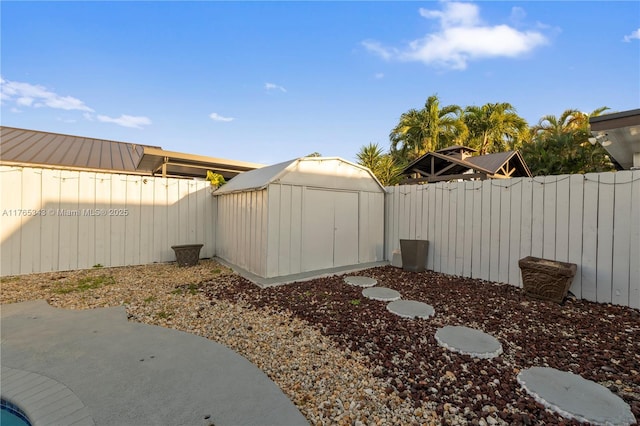 view of yard featuring a fenced backyard, an outbuilding, and a storage shed