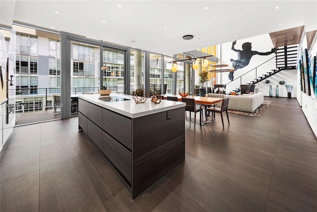kitchen with a wall of windows, black electric cooktop, modern cabinets, and light countertops