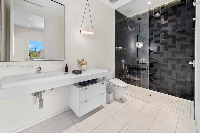 bathroom with tile patterned floors, toilet, walk in shower, and a sink