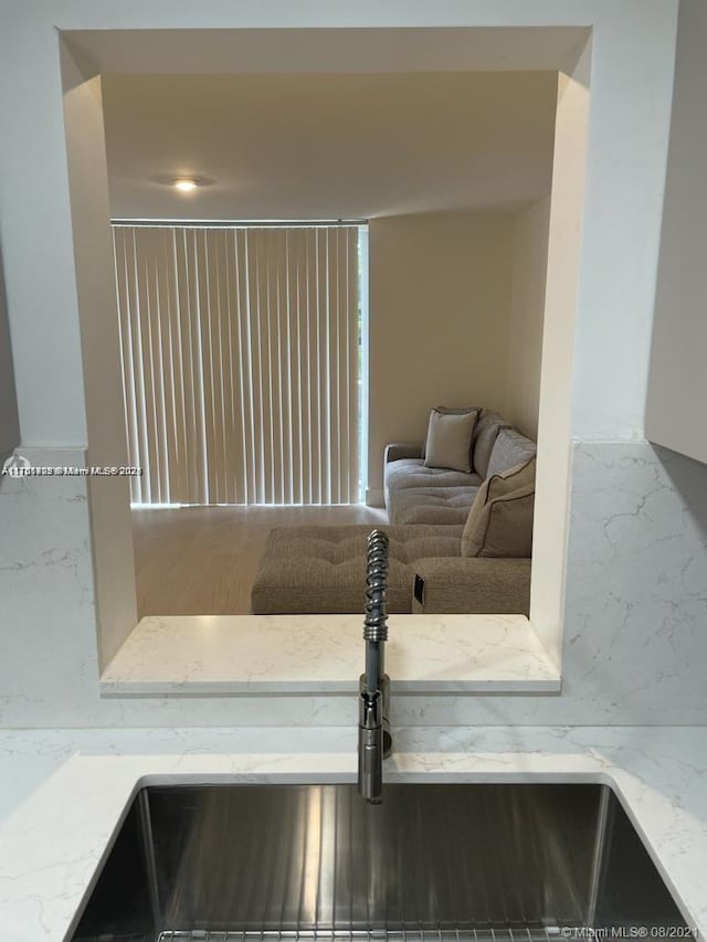 interior space with light stone countertops and a sink
