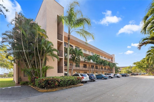 view of building exterior with uncovered parking