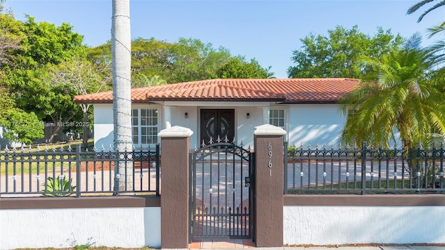 6961 SW 152nd St, Palmetto Bay, FL 33157 - mediterranean / spanish-style house featuring a tiled roof, a fenced front yard, stucco siding, and a gate