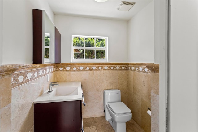6961 SW 152nd St, Palmetto Bay, FL 33157 - bathroom with tile walls, toilet, vanity, a wainscoted wall, and tile patterned flooring