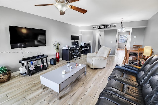 living area featuring wood finish floors, visible vents, baseboards, and ceiling fan