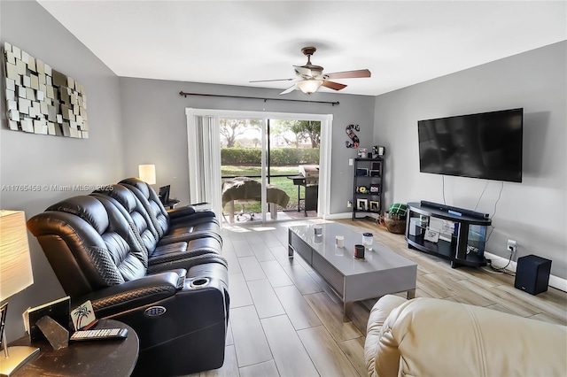living area with wood finish floors, baseboards, and a ceiling fan