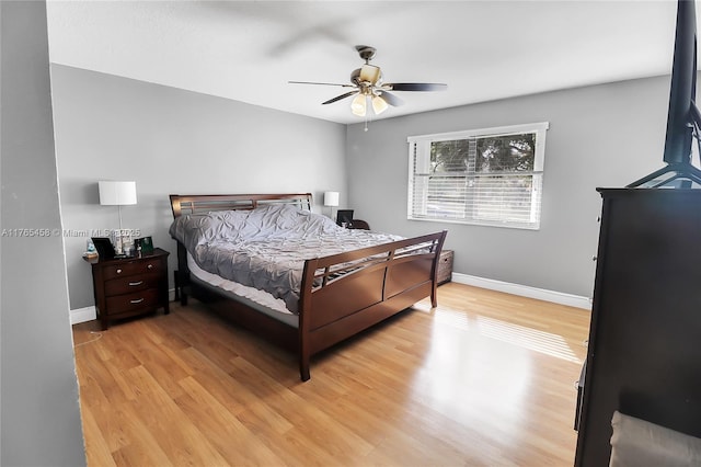 bedroom with light wood-style flooring, baseboards, and ceiling fan