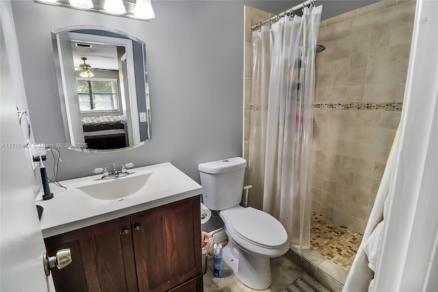bathroom with toilet, a stall shower, ensuite bathroom, ceiling fan, and vanity