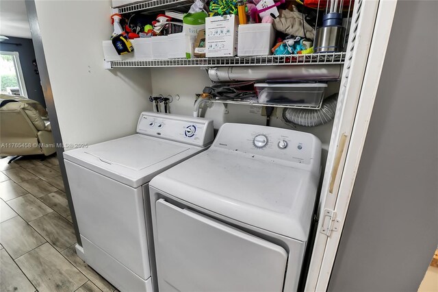 washroom featuring washer and clothes dryer, laundry area, and wood finish floors