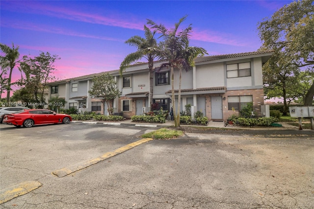 property at dusk featuring uncovered parking