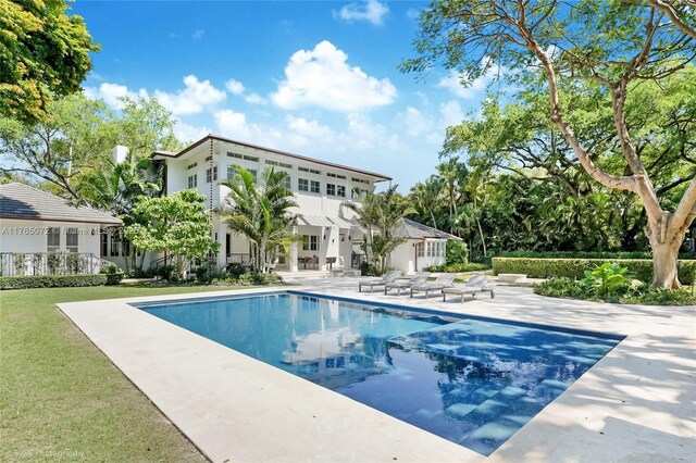 4550 Sunset Dr, Coral Gables, FL 33143 - rear view of house featuring a patio and an outdoor pool