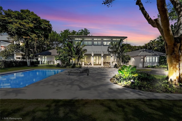 4550 Sunset Dr, Coral Gables, FL 33143 - pool at dusk with an outdoor pool and a patio area
