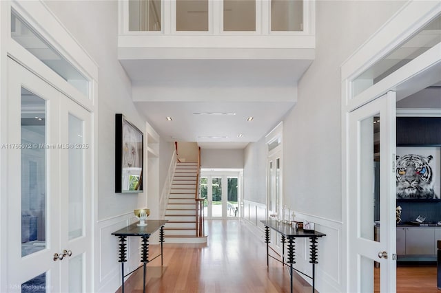 4550 Sunset Dr, Coral Gables, FL 33143 - hall featuring a decorative wall, french doors, wood finished floors, and wainscoting