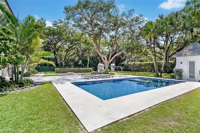 4550 Sunset Dr, Coral Gables, FL 33143 - outdoor pool featuring a yard, a playground, view of scattered trees, and a patio