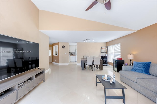 living room with baseboards, ceiling fan, and light tile patterned flooring