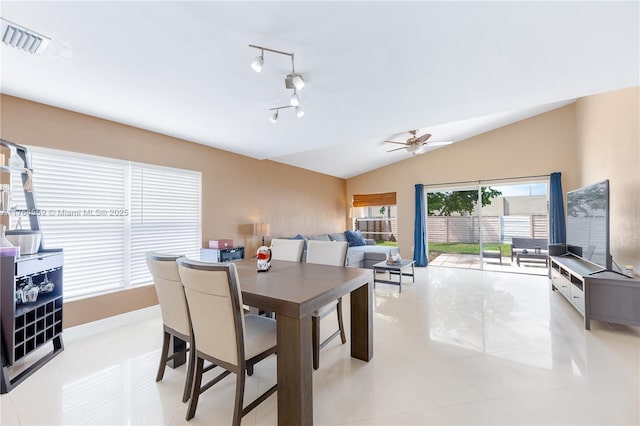 dining space with vaulted ceiling, light tile patterned floors, visible vents, and a ceiling fan