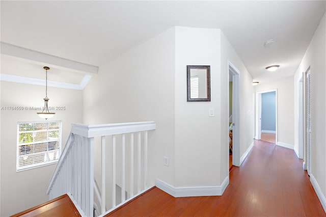 hall with baseboards, an upstairs landing, and wood finished floors