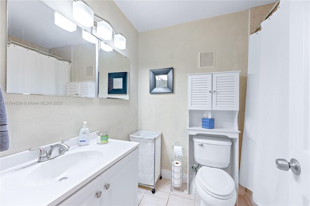 bathroom featuring toilet, visible vents, tile patterned flooring, baseboards, and vanity
