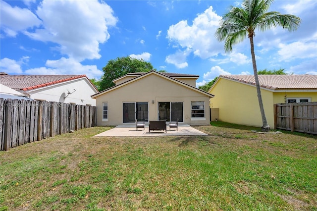 back of house featuring a patio area, stucco siding, a lawn, and a fenced backyard