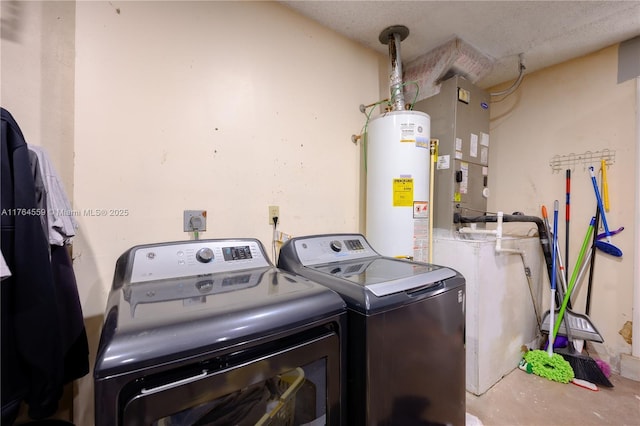 clothes washing area with washing machine and clothes dryer, water heater, and heating unit