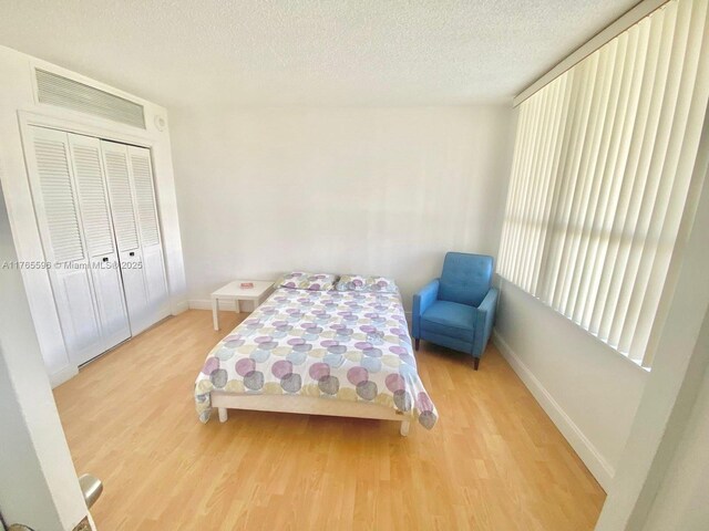 9801 Collins Ave Unit 8M, Bal Harbour, FL 33154 - bedroom with wood finished floors, a textured ceiling, and a closet