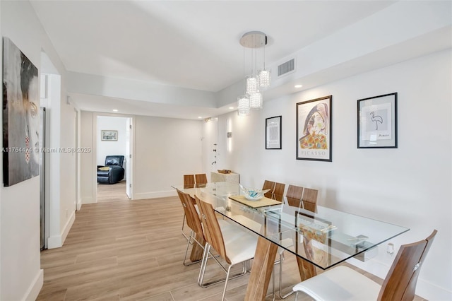 dining area with visible vents, baseboards, an inviting chandelier, and light wood-style flooring