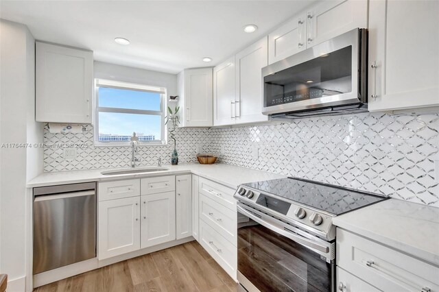 kitchen featuring a sink, light countertops, white cabinetry, and stainless steel appliances