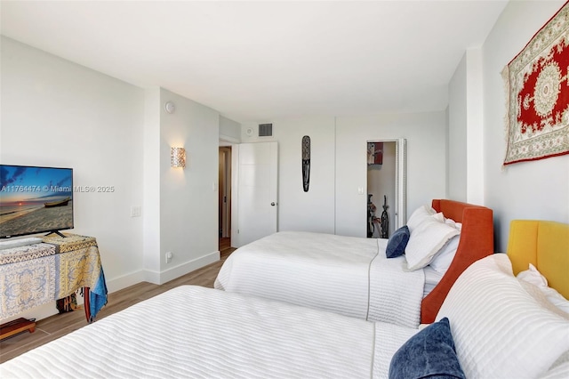 bedroom featuring visible vents, wood finished floors, and baseboards