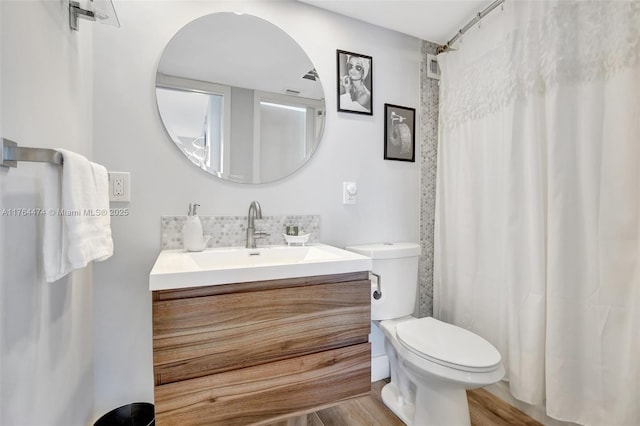 bathroom with curtained shower, toilet, wood finished floors, and vanity