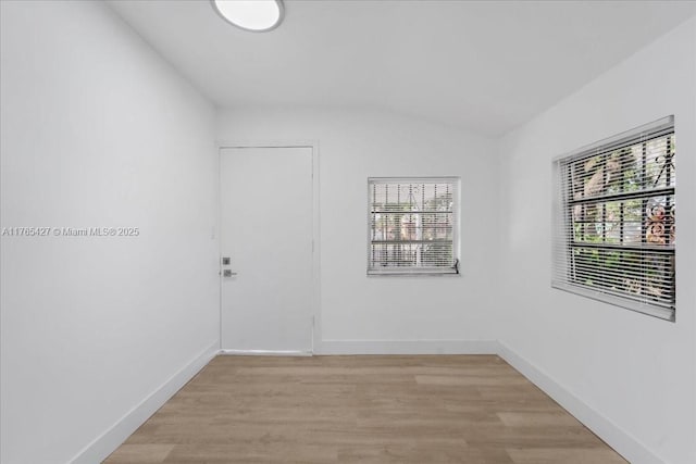 2911 NW 30th St, Miami, FL 33142 - spare room with light wood-type flooring, baseboards, a healthy amount of sunlight, and vaulted ceiling