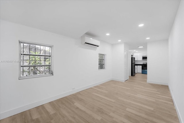 2911 NW 30th St, Miami, FL 33142 - unfurnished room featuring light wood finished floors, baseboards, and a wall mounted air conditioner