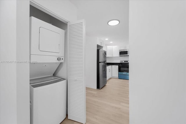 2911 NW 30th St, Miami, FL 33142 - laundry room featuring laundry area, light wood-style floors, and stacked washer and clothes dryer