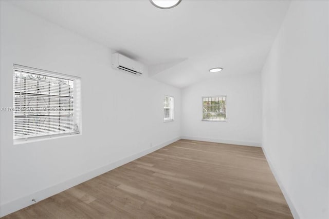 2911 NW 30th St, Miami, FL 33142 - unfurnished room with a wall unit AC, wood finished floors, baseboards, and vaulted ceiling