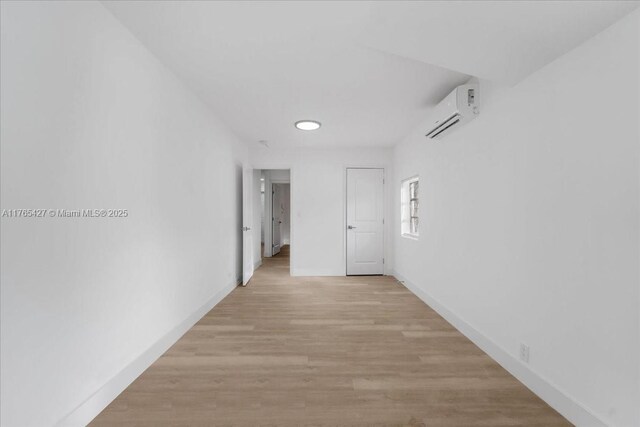 2911 NW 30th St, Miami, FL 33142 - hallway featuring baseboards, light wood-style flooring, and a wall mounted AC