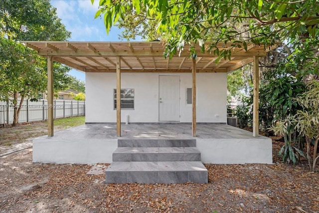 2911 NW 30th St, Miami, FL 33142 - doorway to property featuring a patio area, fence, a pergola, and stucco siding