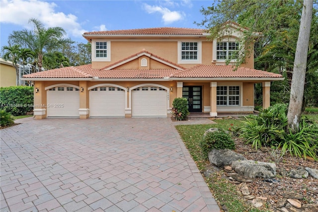 mediterranean / spanish home with stucco siding, decorative driveway, and a tile roof