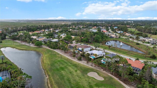 birds eye view of property with view of golf course and a water view