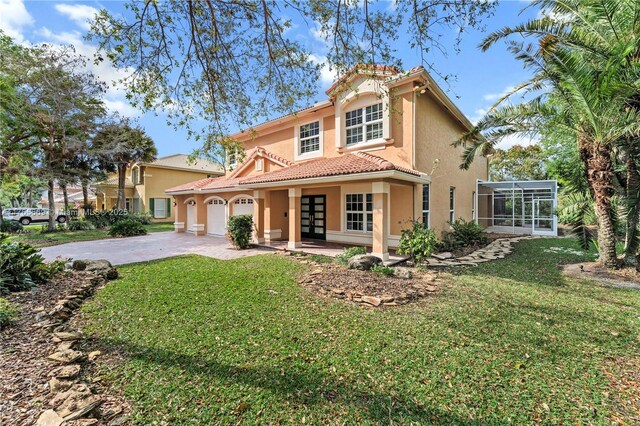 mediterranean / spanish-style home featuring an attached garage, a front lawn, a tiled roof, stucco siding, and driveway
