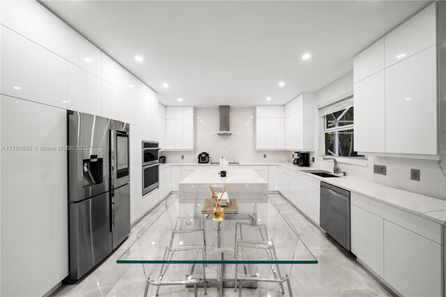 kitchen featuring wall chimney exhaust hood, modern cabinets, and stainless steel appliances