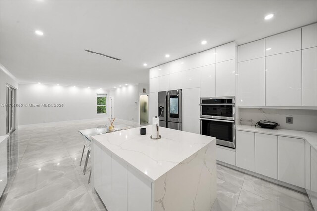 kitchen featuring a center island, white cabinetry, appliances with stainless steel finishes, and modern cabinets