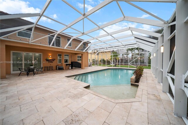 outdoor pool featuring a patio, grilling area, and a lanai