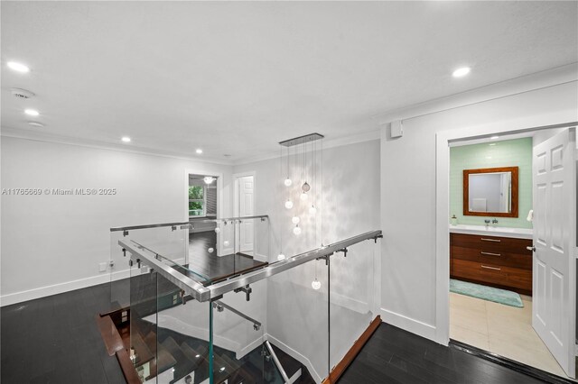 hallway featuring wood finished floors, recessed lighting, an upstairs landing, and baseboards
