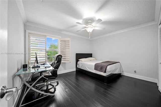 bedroom with ornamental molding, a textured ceiling, baseboards, and wood finished floors